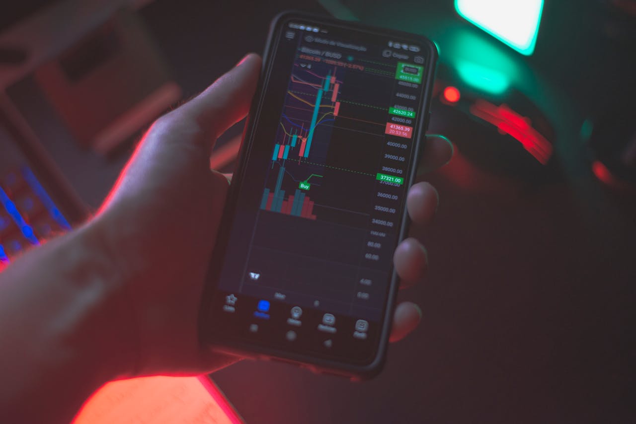 Hand holding smartphone displaying cryptocurrency trading app with financial data.